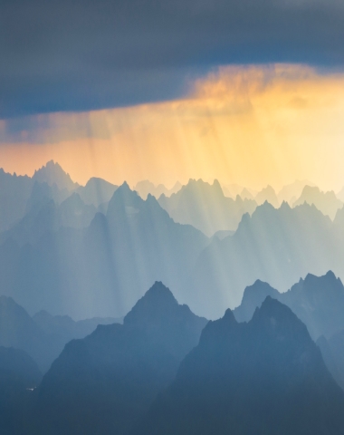 God rays pierce the mist over the rugged mountains of Lofoten
